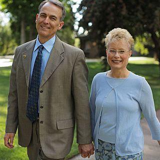 John and 帕姆 麦克维恩 smile at the camera while holding hands